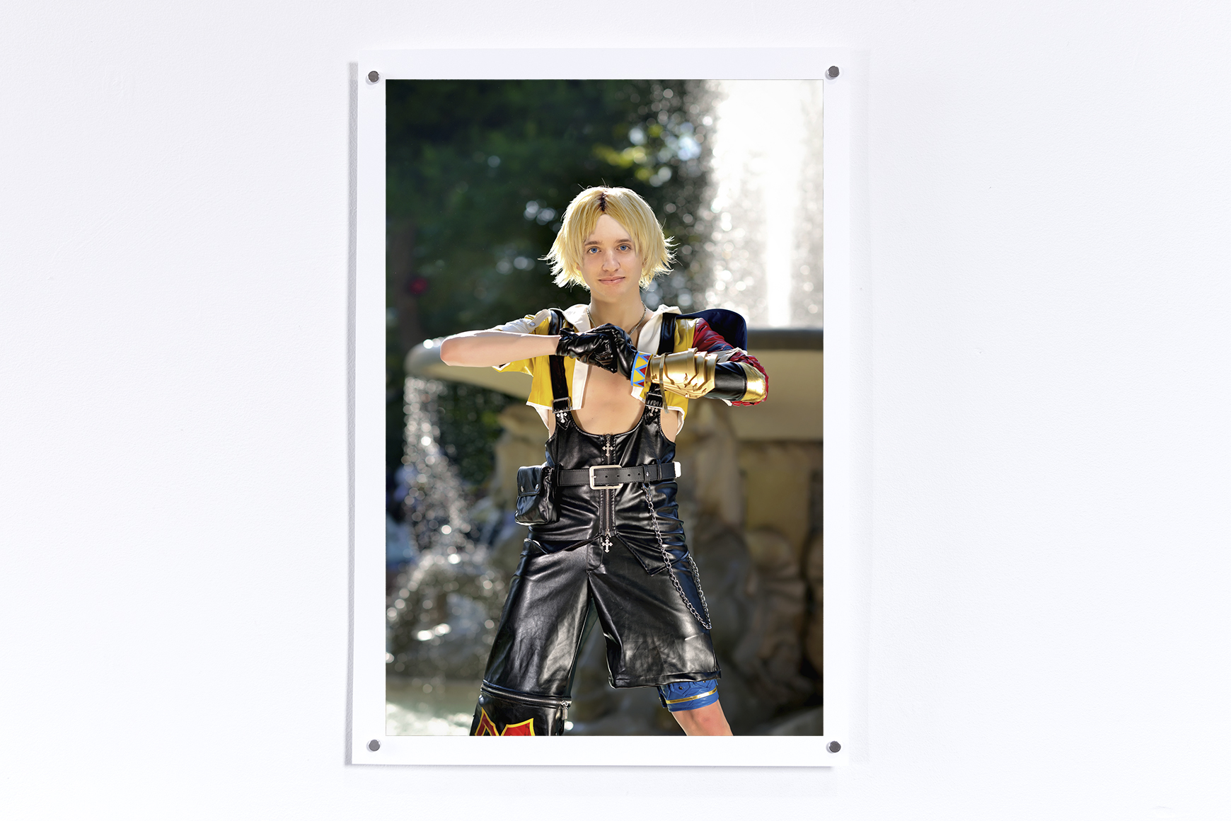 Print hung on a white wall of Tidus from Final Fantasy 10 in front of a fountain with Jesse's face superimposed on the character
